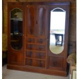 An Edwardian mahogany inlaid compactum wardrobe with mirrored doors flanking central panelled
