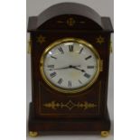 A mahogany cased and brass inlaid thirty hour mantle clock on bun feet with domed top and ring carry