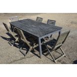 A weathered and worn teak garden table to/w a set of six chairs