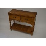 A small oak dresser with two open shelves and two drawers over open pot board undertier raised on