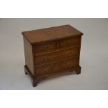 A small Georgian style walnut chest of two over two drawers, raised on bracket feet, 66 cm wide x 58