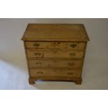 An antique pine chest of four long graduating drawers raised on shaped bracket feet, 78 cm high x 80