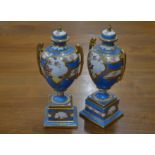 A pair of Continental blue-ground urn vases and covers in the Sevres manner, with floral-painted and