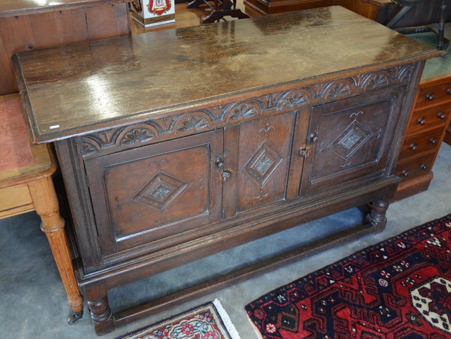 A 19th century lunette carved oak sideboard with panelled doors, turned supports and stretchers,