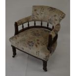 A late Victorian mahogany framed spindle back armchair with floral upholstery, turned supports and