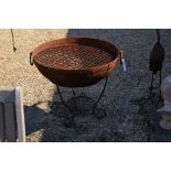 A large weathered (cast finished) firepit on stand