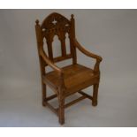 A carved pine Gothic style open armchair