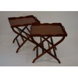 A pair of Georgian style mahogany butler's tables with galleried tray tops and folding stands