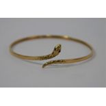 A yellow metal bangle in the form of a coiled serpent,