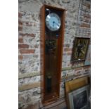 An electric clock, in glazed teak case