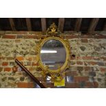 A late 18th/19th century giltwood and composite framed oval mirror with twin candle sconce mount