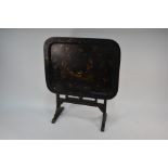 An antique black lacquer and gilt decorated tilt top occasional tray table