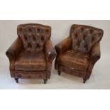 A pair of antique battered brown leather armchairs