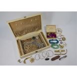 A vintage jewellery box with various items of costume and fashion jewellery