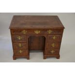 An 18th century feather-banded walnut and fruitwood kneehole desk