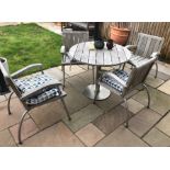 An all-weather weathered teak and marine grade stainless steel circular garden table and four chairs