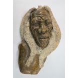 A large hand carved African head with textured dreadlock style hair