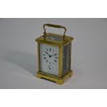 A small lacquered brass carriage travel alarm clock