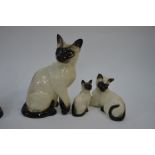 A trio of Royal Doulton Siamese cats