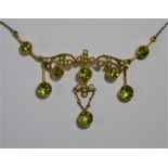 An Edwardian Art Nouveau necklace set with circular peridot and seed pearls