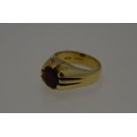 A 15ct yellow gold ring with circular claw set garnet