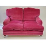 A contemporary dark pink upholstered Howard style two seat sofa