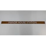 'Manor House Station', a vintage London Underground enamel sign, white lettering on brown