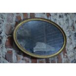 A George III oval wall mirror with beaded gilt frame
