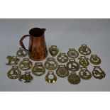 Nineteen various antique horse-brasses to/w a copper jug