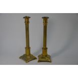 A pair of 19th century Empire-style brass pillar candlesticks on stepped square base