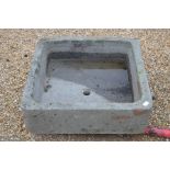 A large hollowed stone square garden sink or planter