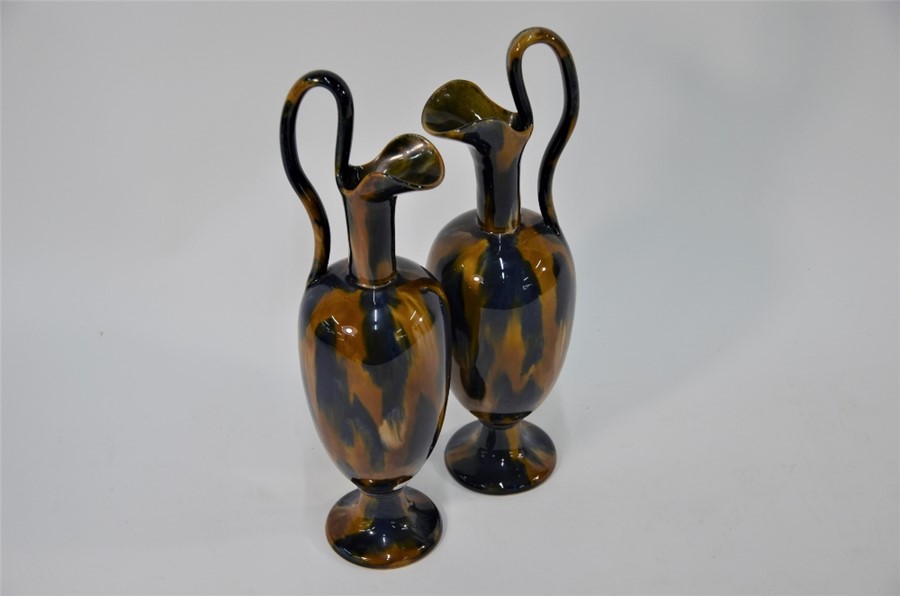 WITHDRAWN A pair of stoneware ewers of slender form