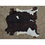A brown and cream cow hide rug