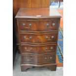 A Georgian style mahogany serpentine front bedside chest