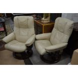 A pair of 'Stressless' reclining armchairs with cream leather upholstery