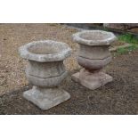 A pair of Georgian style cast stone garden urn planters