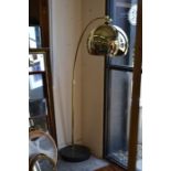 A polished brass-finished Arc floor lamp