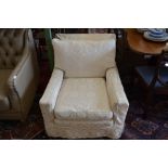 Deep seated upholstered armchair with loose cream damask style covers