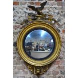 A large Regency giltwood eagle and serpent surmounted convex mirror