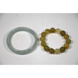 A Chinese pale green hardstone bangle to/w a quartz bracelet (2)