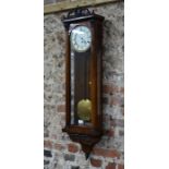 An antique redwood Vienna regulator style wall clock