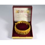 An Eastern style yellow metal filigree wide half hinged bangle