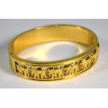 A yellow metal bangle with elephant decoration