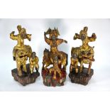 Three 20th centruy Chinese carved hardwood immortal figures with gilt and polychrome decoration