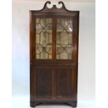 A George III mahogany two-part corner cupboard