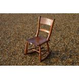 An antique fruit wood children's rocking chair