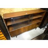 A 1970s teak bookcase with sliding glass panels