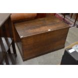 An antique stained oak coffer with hinged three-plank top