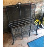 A large wrought iron fire basket and two spark guards