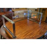 A contemporary glass top coffee table on open chromed box supports